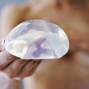 Frau hält Silikon-Implantat in der Hand