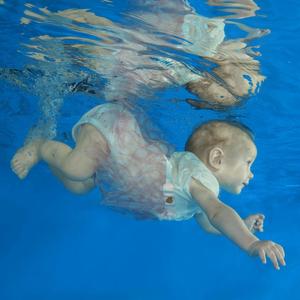 Säugling taucht in Schwimmbecken