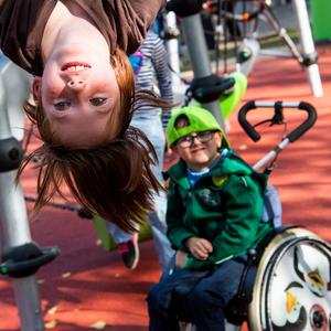 Zwei Kinder auf einem barrierefreien Spielplatz.
