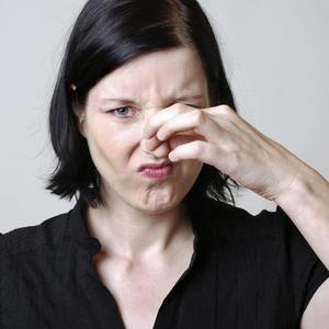 Frau hält sich die Nase zu