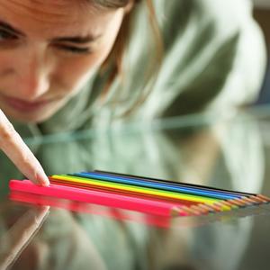 Frau sortiert Stifte nach Farbe