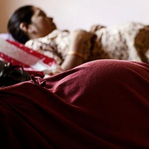 Zwei werdende Mütter liegen auf den Betten einer Klinik für Leihmutterschaften in Anand, Indien.