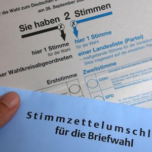 Ein Stimmzettel und ein Umschlag für die Briefwahl liegen auf einem Tisch