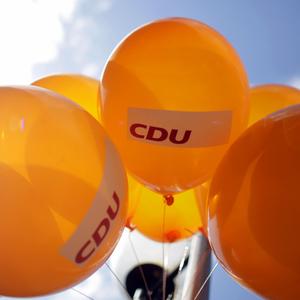 Orangene Luftballons mit dem Logo der CDU