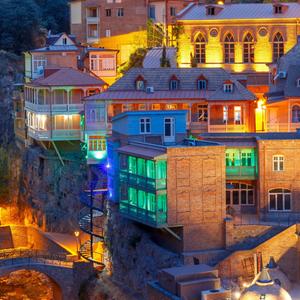 Erstaunliche Aussicht auf berühmte bunte Häuser und Balkone im alten historischen Viertel Abanotubani in der Nachtbeleuchtung während der blauen Morgenstunde