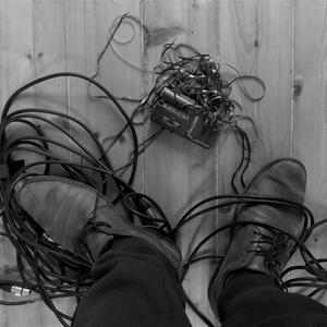 Ein Diktiergerät liegt mit Bandsalat vor den Füßen eines Mannes