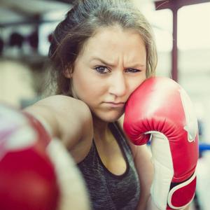 Ein Mädchen boxt mit grimmigem Gesichtsausdruck: Es gibt zahlreiche Beispiele für sexualisierte Gewalt im Sport. Betroffene fühlen sich gedemütigt oder erniedrigt. Fachleute erforschen das Ausmaß der sexualisierten Gewalt im Sport und welche Faktoren