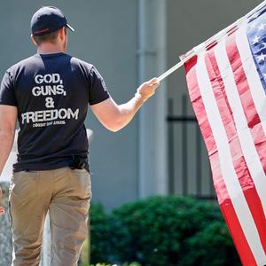 God, Guns &amp; Freedom: Ein Mann mit der US-Flagge bei Protesten am 2. Mai 2020 in Morganton / North Caroline. Gut 50 Menschen forderten den Gouverneur von North Carolina, Roy Cooper, auf, die Beschränkungen, die wegen der COVID-19-Pandemie verhängt wo