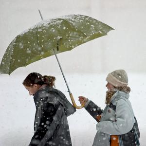 Zwei Frauen teilen einen Schirm