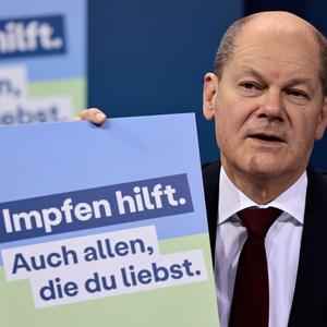 Bundeskanzler Olaf Scholz (SPD) präsentiert ein Plakat für eine neue Impfkampagne während einer Pressekonferenz nach einem Treffen im Kanzleramt, Januar 2022