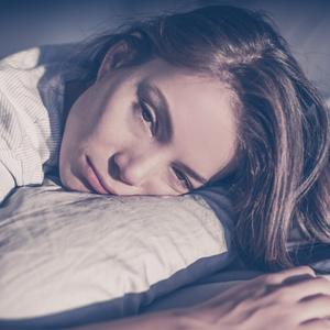 Das Fatigue-Syndrom ist häufig bei Long-Covid-Patientinnen. Eine Frau liegt auf einem Kissen.