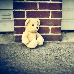 Teddy sitzt allein und traurig auf dem Boden