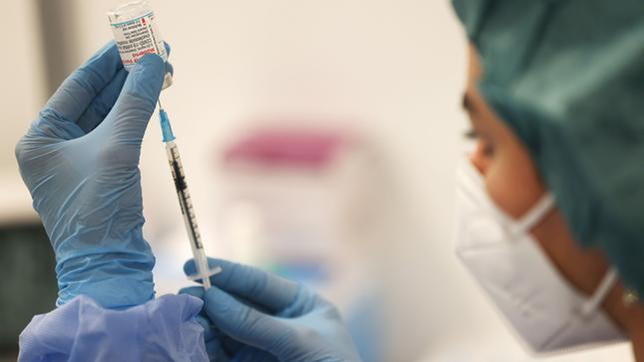 Eine Pharmazeutin zieht eine Spritze mit dem Impfstoff von Moderna auf.