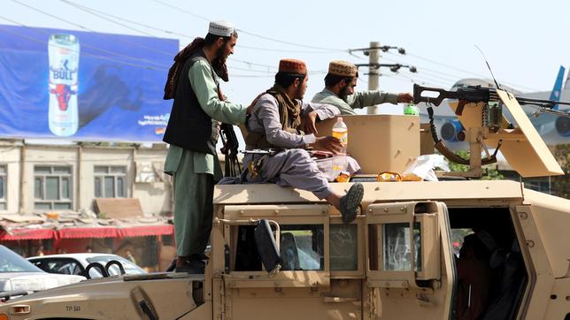 Bild: picture alliance/dpa/AP Taliban-Kämpfer stehen vor dem internationalen Flughafen Hamid Karzai Wache.