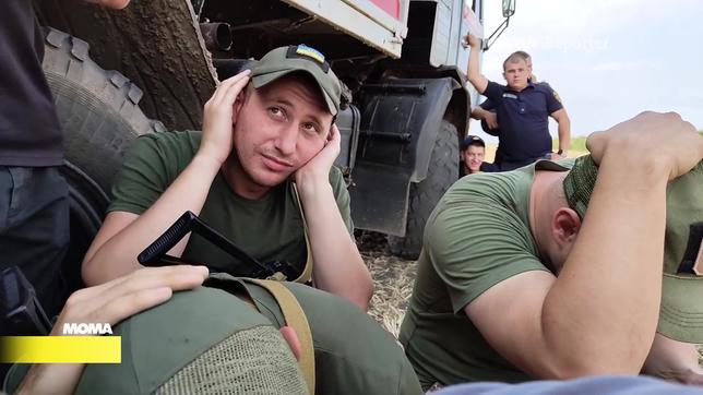 Ukraninische Mineräumer halten sich die Ohren zu. 