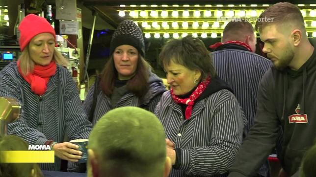 MOMA-Reporterin Victoria Reith zapft Glühwein auf einm Kölner Weihnachtsmarkt