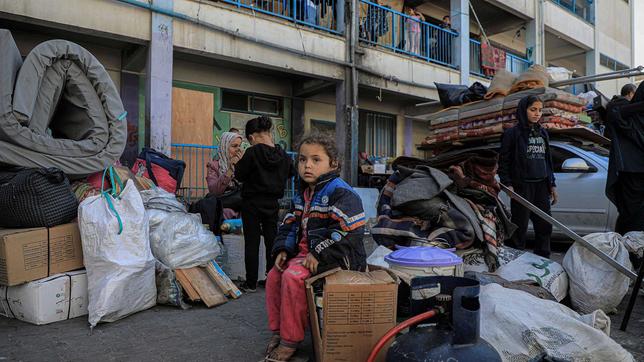 Ein Mädchen sitzt in den Trümmern von Rafah