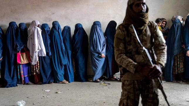 Taliban bedroht afghanische Frauen  mit einem Maschinengewehr