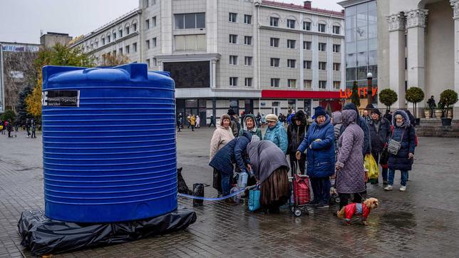 Menschen stehen in Cherson an einem öffentlichen Brunnen an.