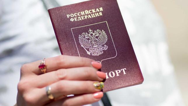 Frauenhand hält einen russischen Pass