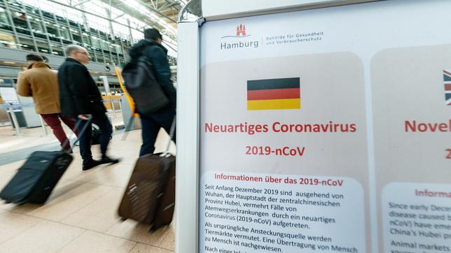 Bild: dpa/Markus Scholz Im Flughafen Hamburg informiert ein Aufsteller über das Coronavirus