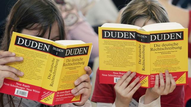 zwei Kinder lesen im Duden, deutsche Sprache