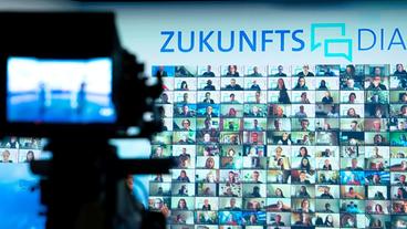 Bild: WDR/Annika Fußwinkel Eine Kamera ist auf einen Videowand zum ARD-Zukunftsdialog gerichtet.