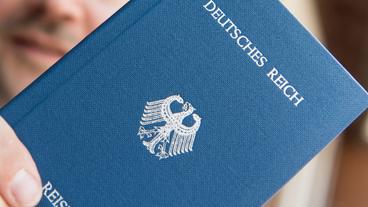Bild: dpa In einer Hand wird ein Heft mit dem Aufdruck «Deutsches Reich Reisepass» gehalten.