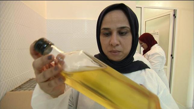 Eine Frau begutachtet eine Flasche mit Argan-Öl.