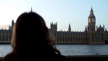 Ein Frau von hinten, im Hintergrund das britische Parlament.