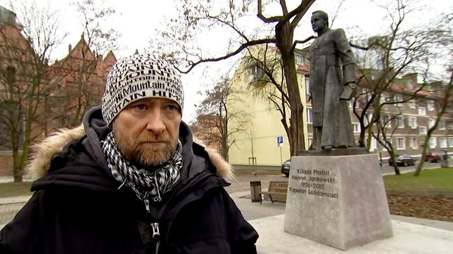 Michal Wojciechowicz  vor der Statue von Pfarrer Henryk Jankowski 