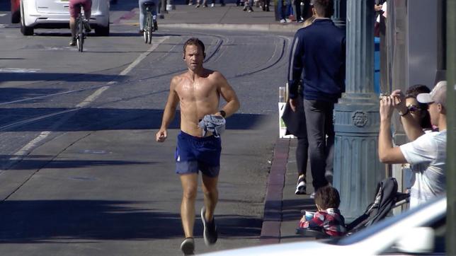 Ein Jogger läuft eine Straße entlang