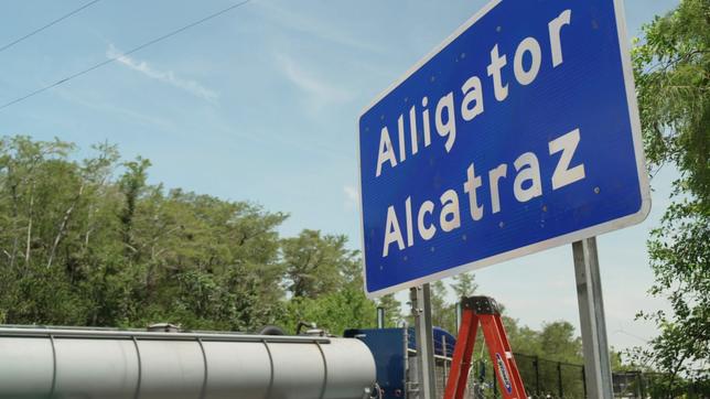 Schild mit der Aufschrift "Alligator Alcatraz" an einer Straße.