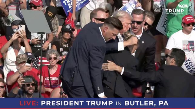 Sicherheitsleute führen den verletzten Donald Trump von einer Bühne.