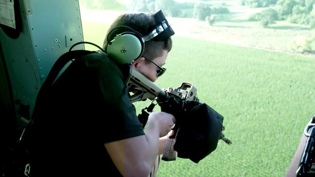 Ein junger Mann mit einem Maschinengewehr im Anschlag.