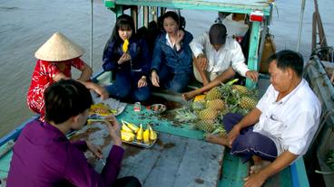 Auf einem Boot sitzen und essen mehrere Menschen