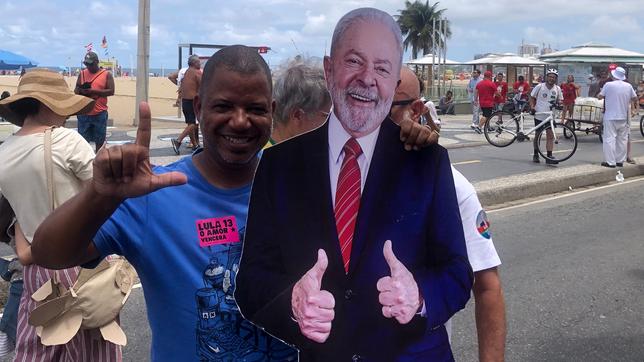 Ein Mann posiert mit einem Pappkonterfei von  Lula da Silva
