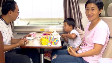 Eine Familie sitzt an einem Tisch in einem Wohnmobil.