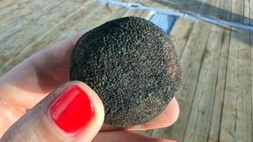 Bild: NDR Schwarze Kugel in der Hand einer Frau.