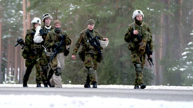 Ein Gruppe von Soldaten laufen auf einer Straße.