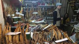 Ein Fischhändler auf dem Markt bietet seine Ware an. 