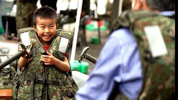 Kleiner Junge in einer Militärweste.