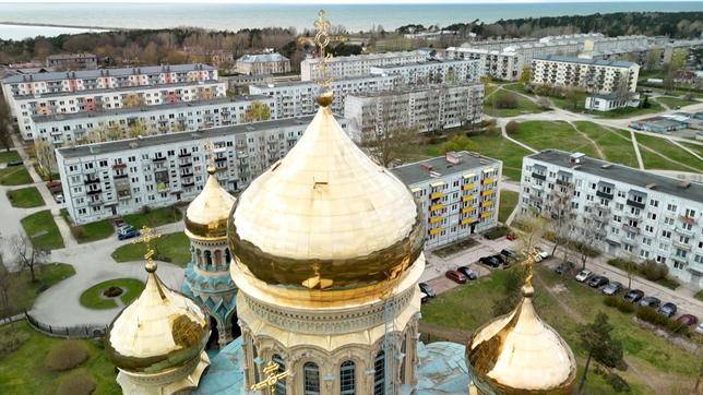 Basilika mit goldem Dach und Plattenbauten.