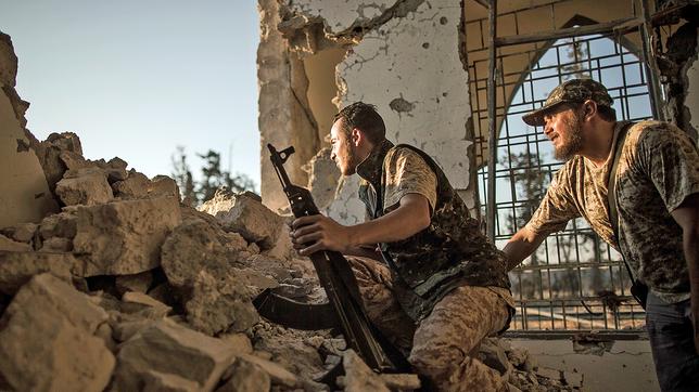 Zwei Kämpfer der von der Regierung unterstützten Truppen, verschanzt mit Waffen in einer zerstörten Moschee.