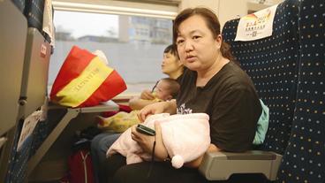 Lily im Zug, auf dem Arm ein Säugling
