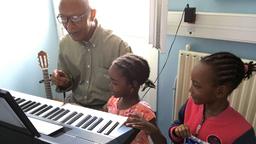 Zwei kleine Mädchen mit Musiklehrer