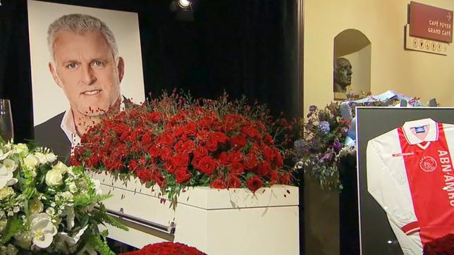 Sarg mit Rosen und Bild des Verstorbenen im Hintergrund.