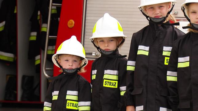 Kleine Mädchen in Feuerwehruniformen