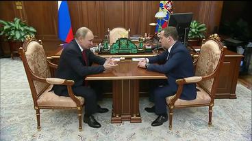 Putin und Medwedew sitzen an einem Tisch.