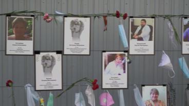 Gedenktafel mit Fotos von Corona-Opfern